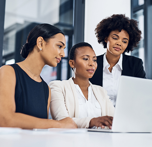 Three colleagues gathered at a laptop