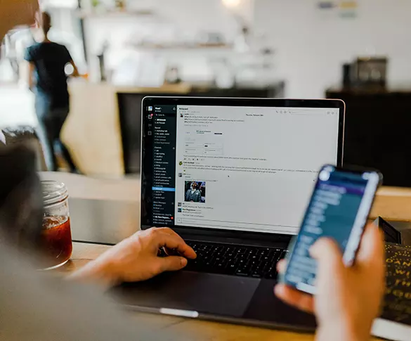 Person on phone and laptop tab image